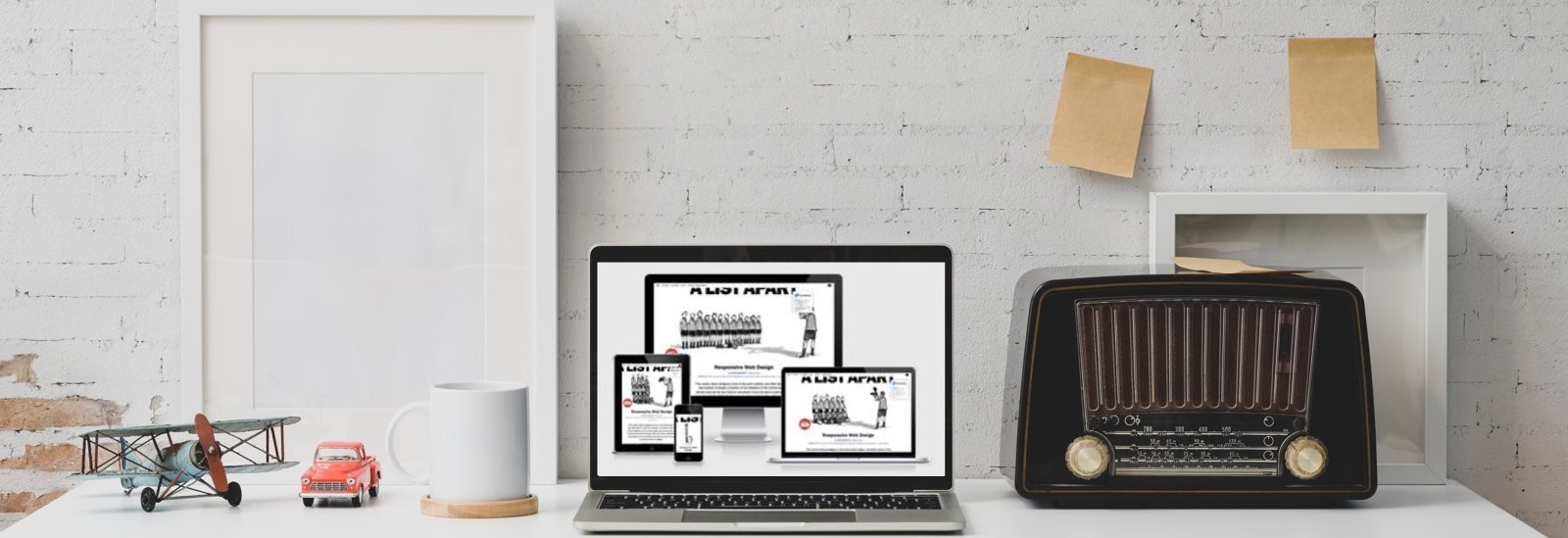 Schreibtisch mit Notebook. Auf dem Display sind Screenshots des Artikels von Ethern Marcotte im Responsive Design zu sehen